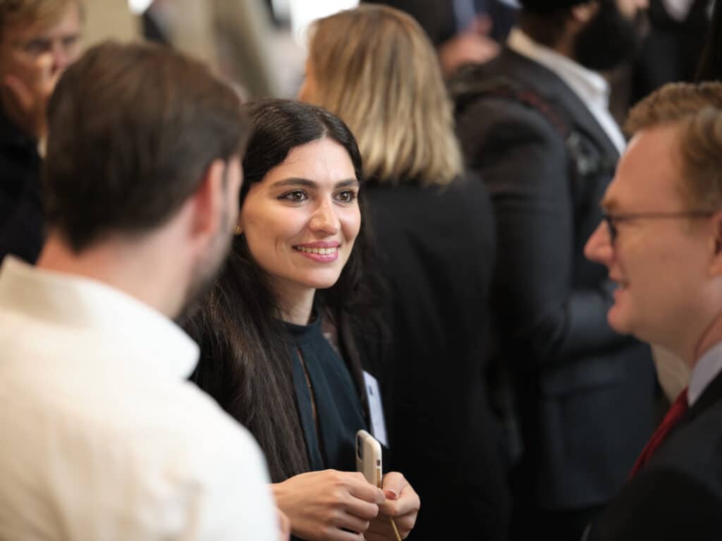 NLP4SF Gallery female delegate smiling and talking to two men.